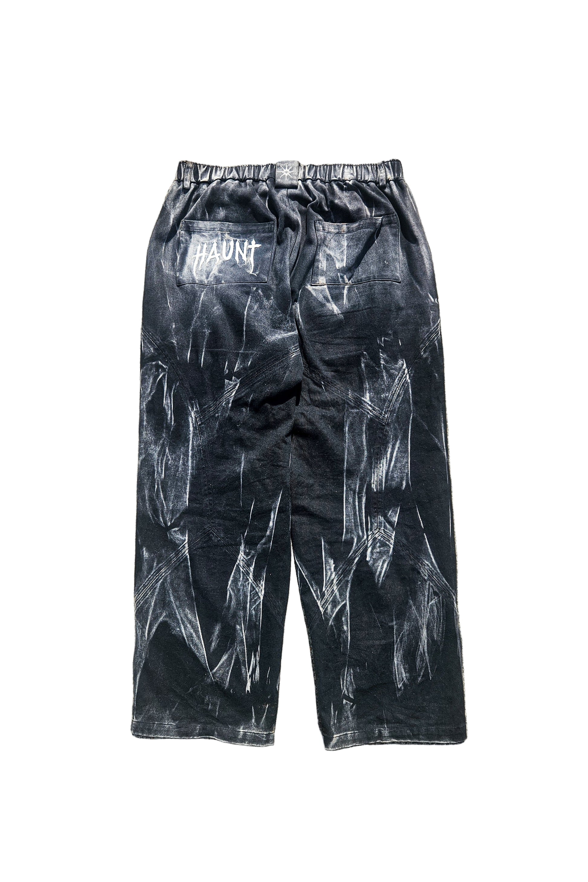 Black pants with white patterns on a gray pavement