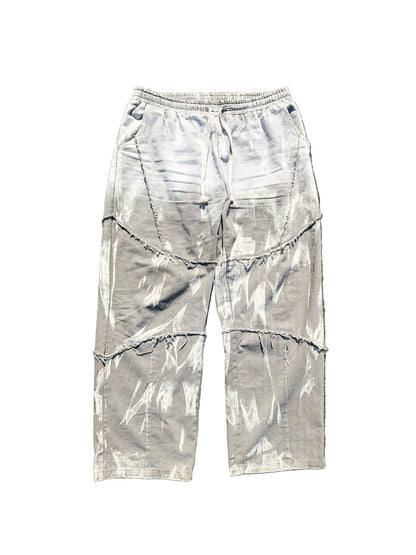 Gray tie-dye pants on a textured brown surface