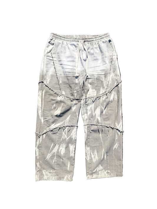 Gray tie-dye pants on a textured brown surface
