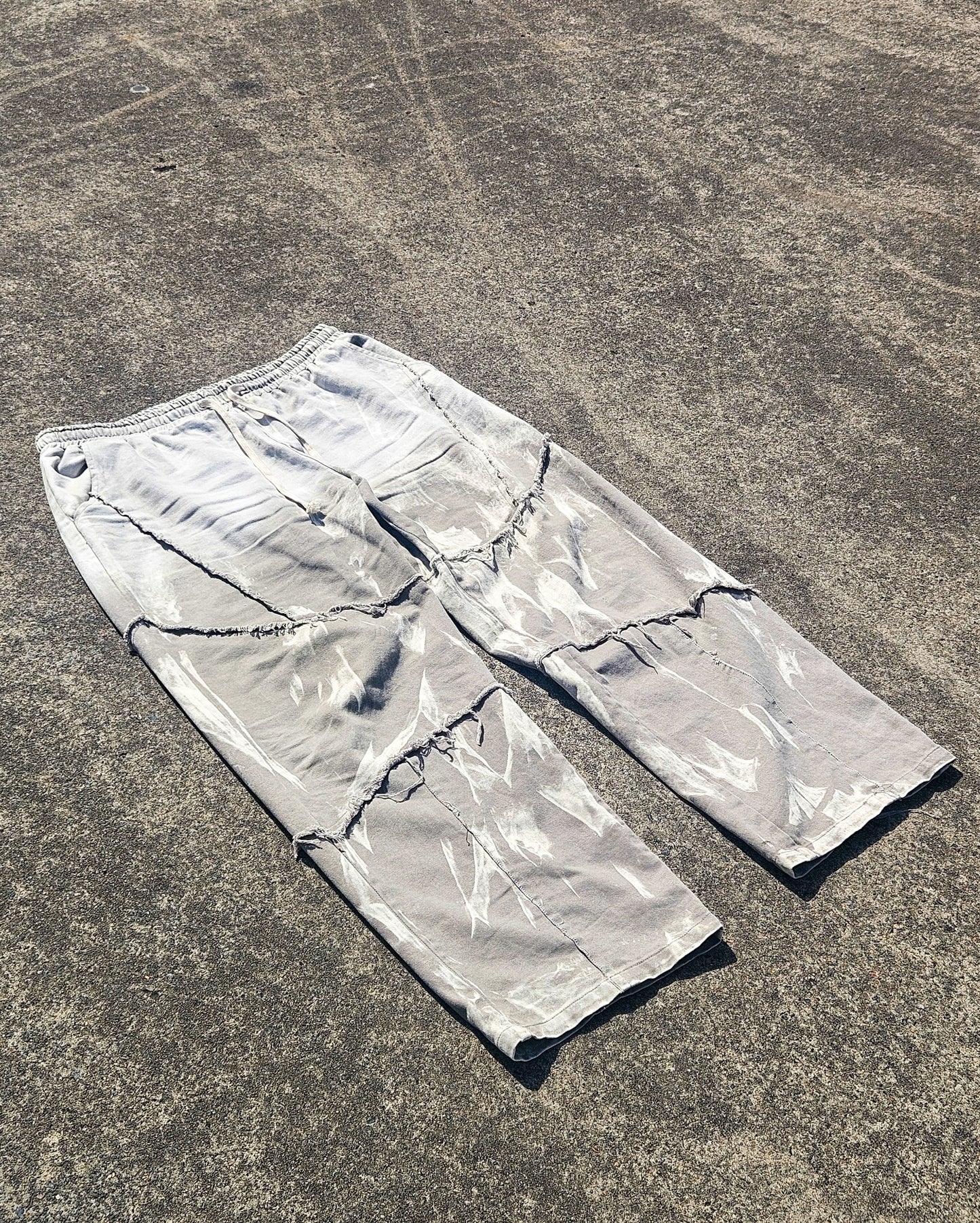 Silver reflective pants on a textured gray surface