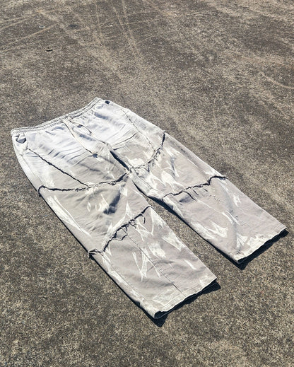 Silver reflective pants on a textured gray surface